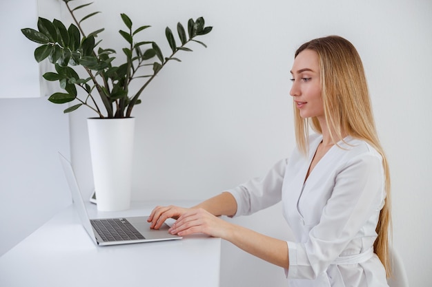 Young woman beautician using laptop in beauty salon