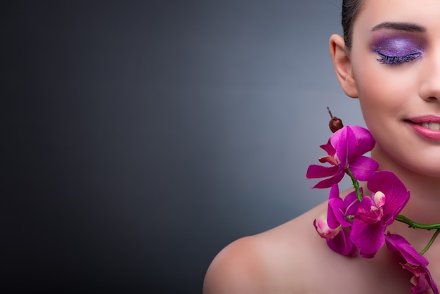 Young woman in beauty concept with orchid flower