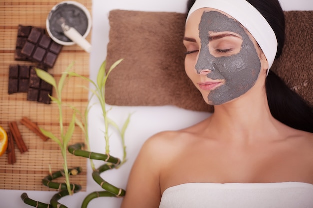 Young woman in beauty salon having face mask