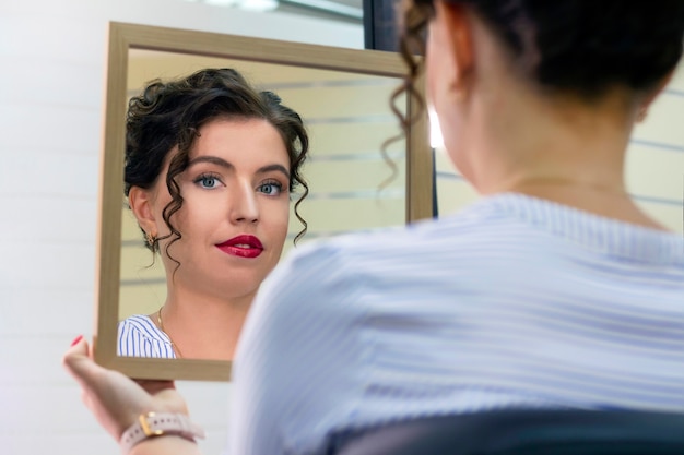 Foto giovane donna in un salone di bellezza guardarsi allo specchio