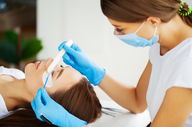 Young woman in a beauty studio on an eyelash extension procedure