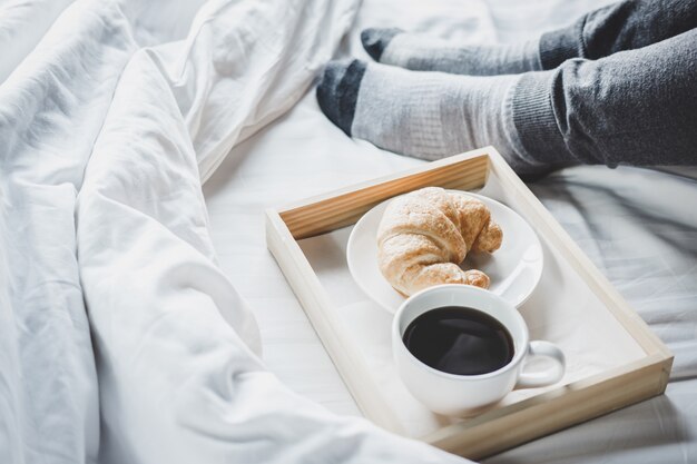 Young woman on the bed with enjoying reading newspaper in holiday and morning coffee 