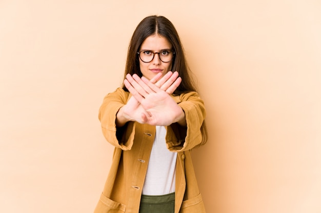 Young woman on beige doing a denial gesture