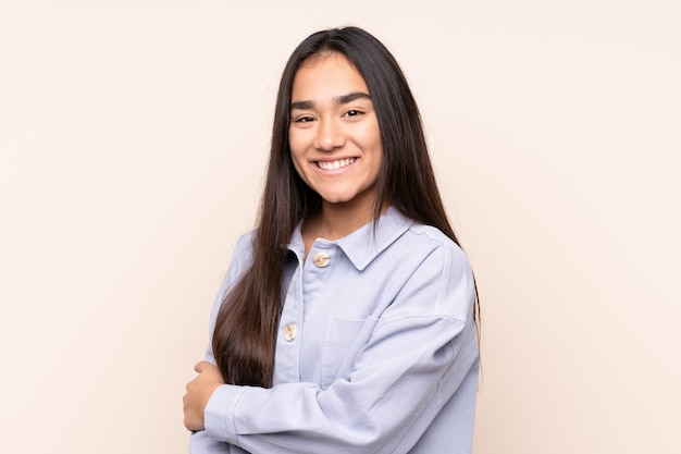 Young woman on beige laughing