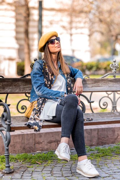 A young woman being bored on a bench