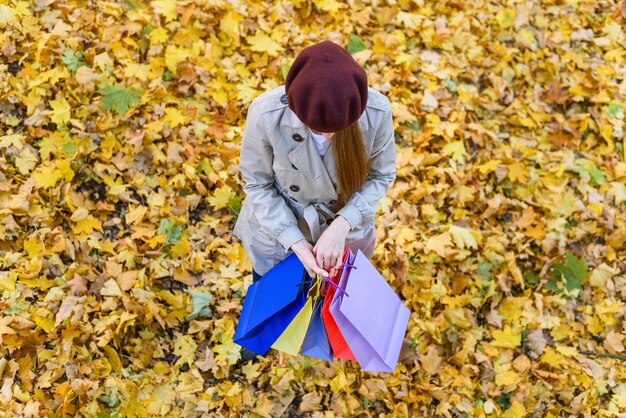 Photo young woman in beret in hands in autumn park. retro style. top view.