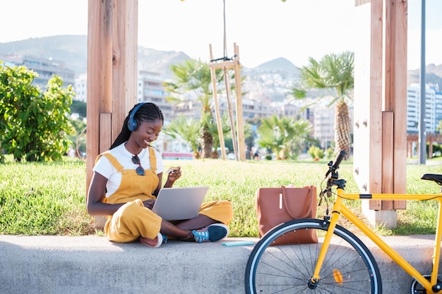 노트북 콘셉트 라이프 스타일 도시 라이프와 함께 야외에서 쇼핑을 하는 자전거 타는 젊은 여성