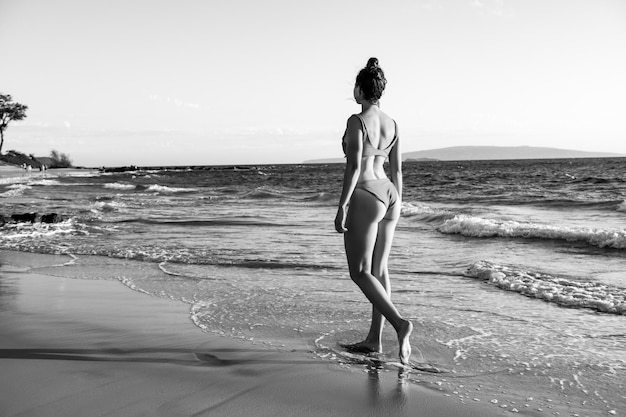 Young woman in bikini on tropical beach Beautiful latin girl in swimwear with copy space Summer vaca...