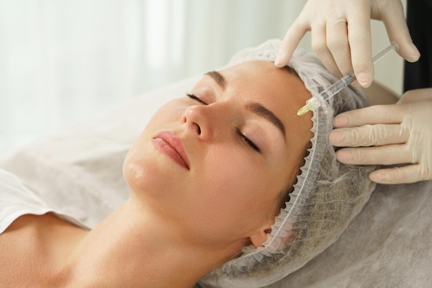 Young woman during biorevitalization procedure in aesthetics medical clinic