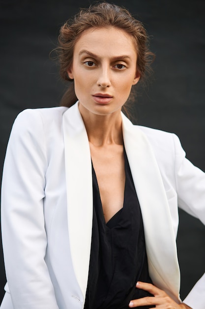 Young woman in a black bodysuit and a white jacket