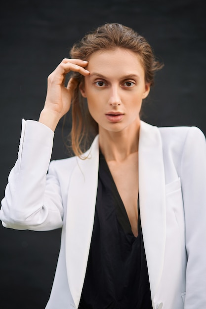 Young woman in a black bodysuit and a white jacket