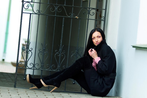 Молодая женщина в черном пальто на улице в холодную погоду Городской портрет