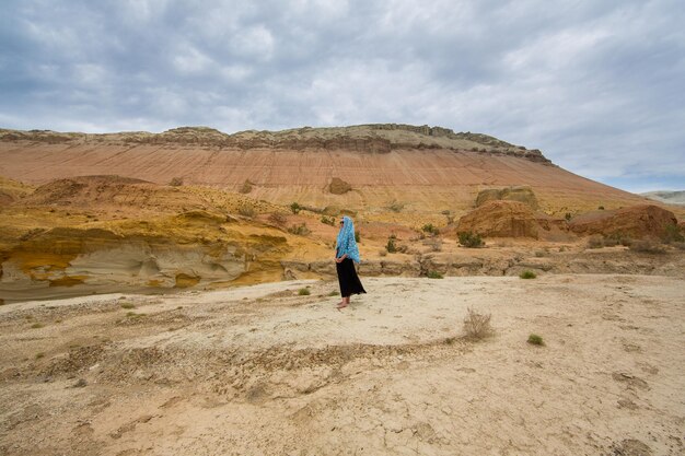 young woman in a black dress in the desert