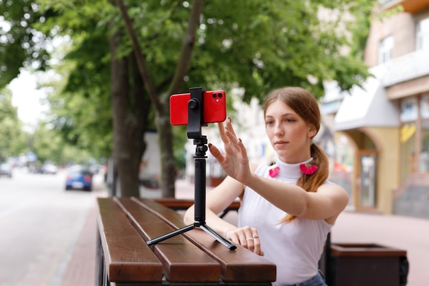 A young woman blogs while sitting outside in the summer