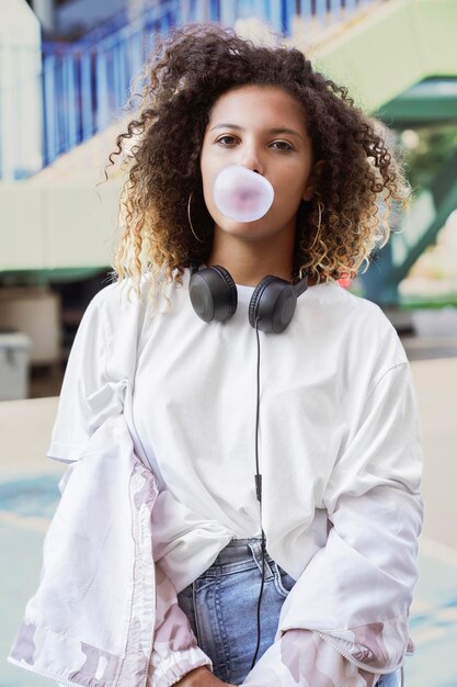 Young woman blowing bubble gum