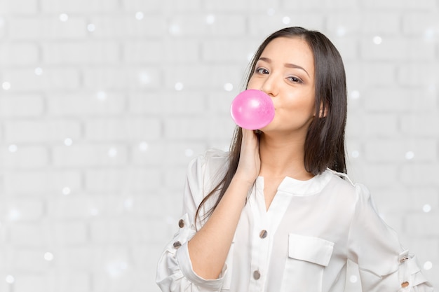 Photo young woman blowing bubblegum