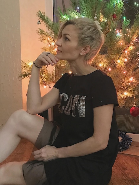 Photo young woman blowing bubbles while sitting on sofa at home