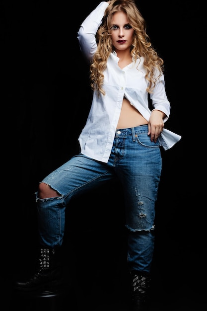 Photo young woman in blue denim and white shirt on black background