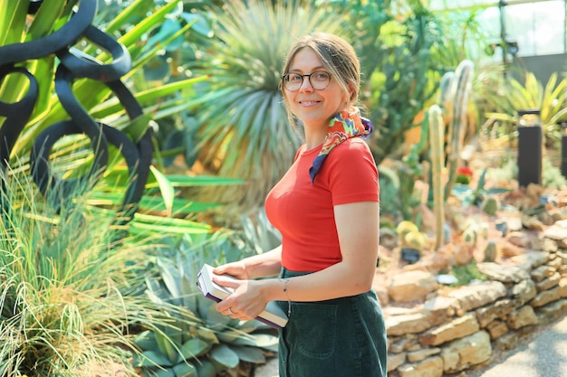 Young woman botanist student in a botanical garden