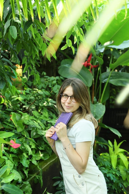 Молодая женщина-ботаник за работой в ботаническом саду
