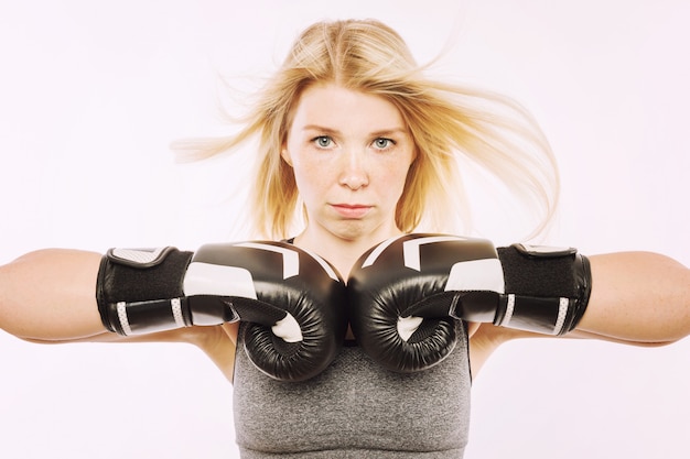 Foto giovane donna in guantoni da boxe nel rack