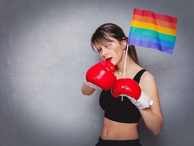 Young woman in boxing gloves with LGBT flag