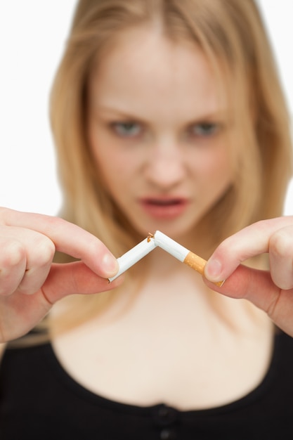 Photo young woman breaking a cigarette