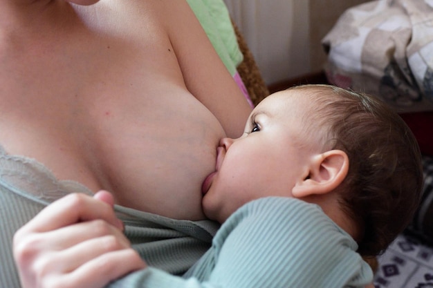 Young woman breastfeeding her baby at home Milk from mothers breast is a natural medicine to baby Mother day bonding concept with newborn baby nursing