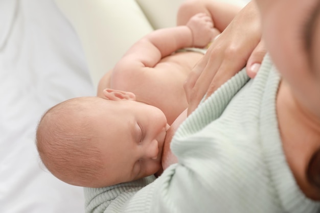 Young woman breastfeeding her little baby above view