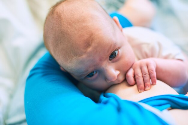 Foto giovane donna che allatta al seno il suo piccolo bambino infantile a casa