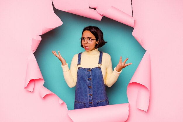 Photo young woman behind a broken wall confused