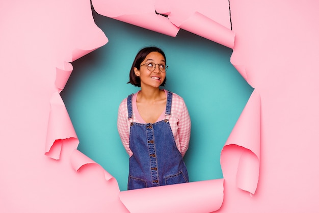 Young woman behind a broken wall looking up