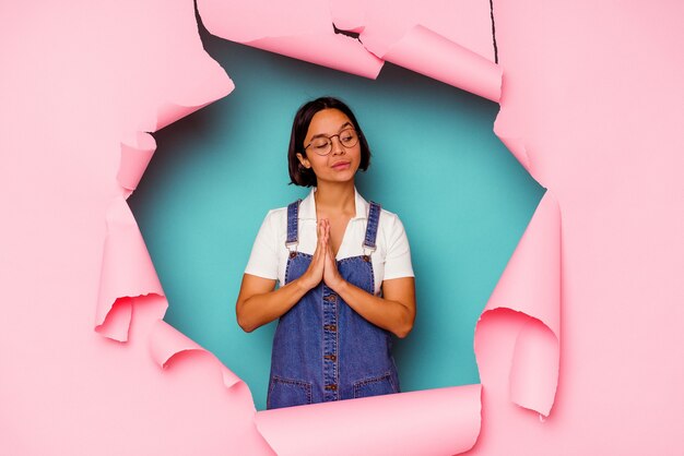 Young  woman behind a broken wall praying