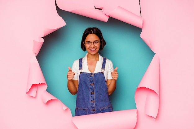 Young woman behind a broken wall smiling confident