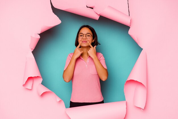 Young woman behind a broken wall