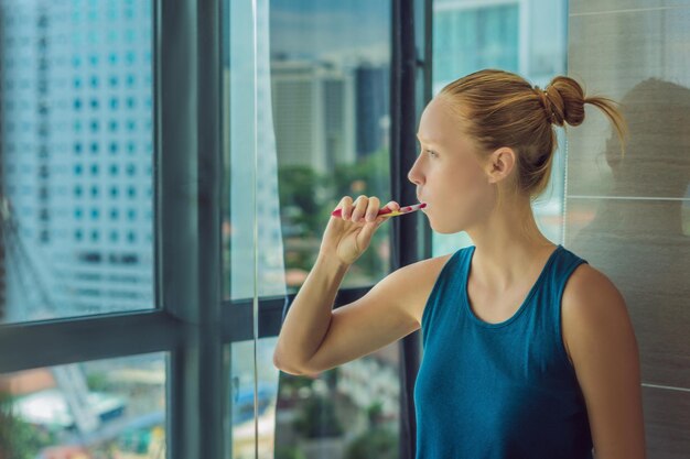 Young woman brushing his teeth in my bedroom