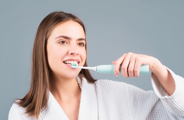 Young woman brushing teeth Beautiful smile of young woman with healthy white teeth Isolated background Dental care White tooth