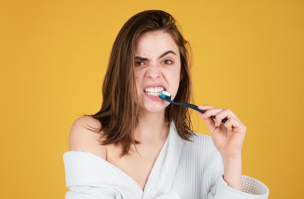 Photo young woman brushing teeth happy funny girl brush her teeth on isolated background beautiful wide smile of young woman with great healthy white teeth