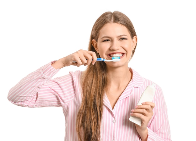 Young woman brushing teeth on white