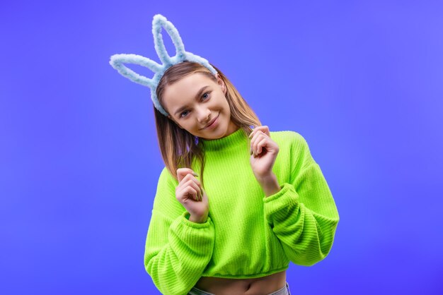 Young woman in bunny ears on a blue background