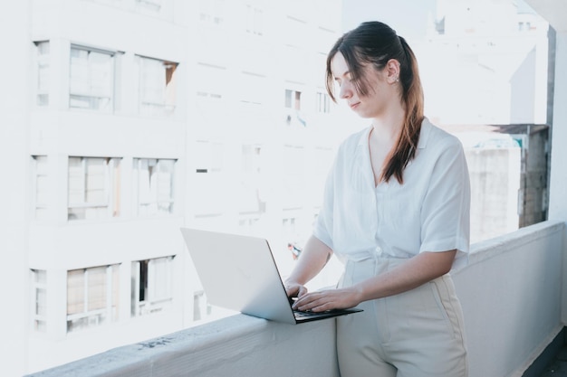 Young woman businesswoman freelancer using laptop for work\
outdoors on a balcony freelance work vacations business people\
technologies distance studying elearning lifestyle meeting\
online