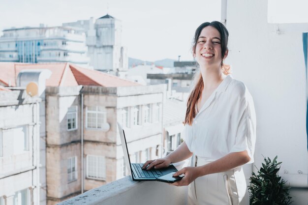 Young woman businesswoman freelancer using laptop for work\
outdoors on a balcony freelance work vacations business people\
technologies distance studying elearning lifestyle meeting\
online