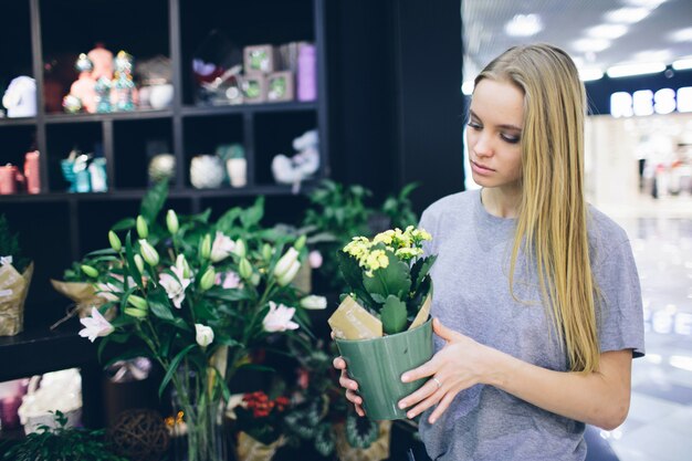 Молодая женщина покупает цветы