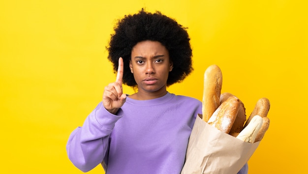Молодая женщина, покупая хлеб на изолированном фоне