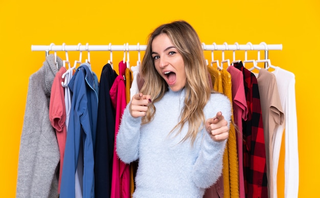 Young woman buying some clothes over isolated wall over isolated wall