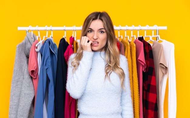 Young woman buying some clothes over isolated wall