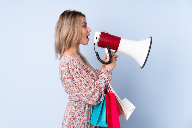 Young woman buying something over isolated blue background