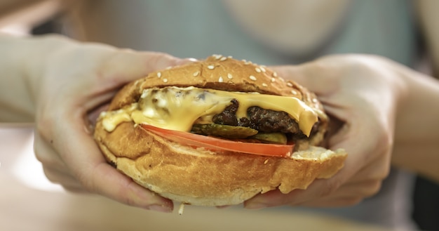 Young woman in cafe eats sandwich, closeup