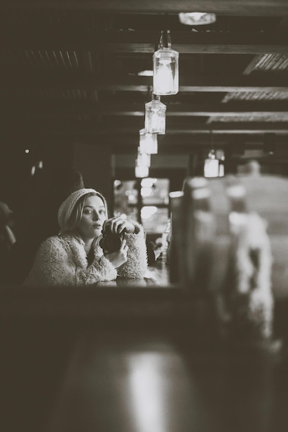 A young woman in a cafe takes pictures of herself in the mirror