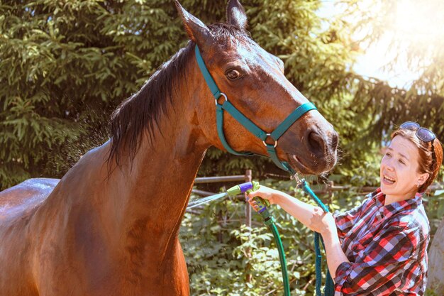 A Young Woman Calls a Horse to Obedience While Washing